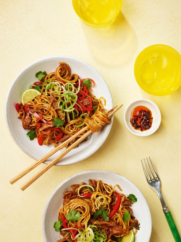 Two bowls of noodles with meat and vegetables.