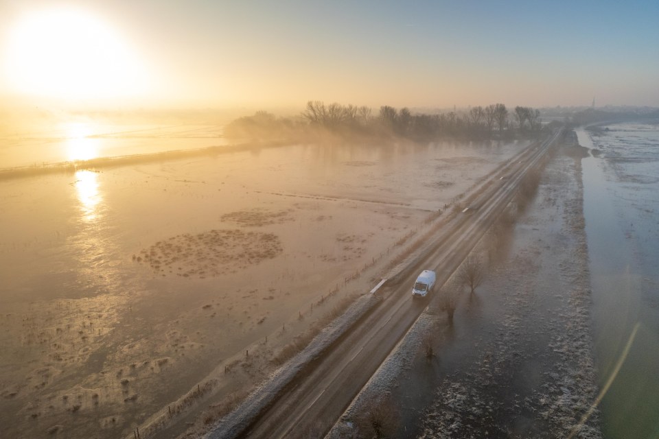 Aerial view of a flooded road at sunrise.