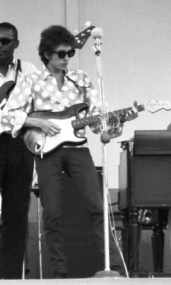 Black and white photo of Bob Dylan and his band performing at the Newport Folk Festival.