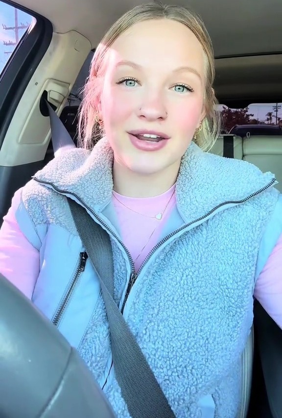 Woman in a car talking to the camera.