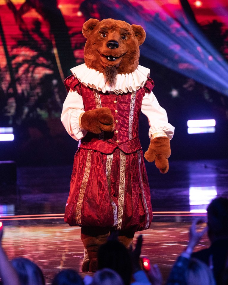 Bear costume on stage with dancers in The Masked Singer.