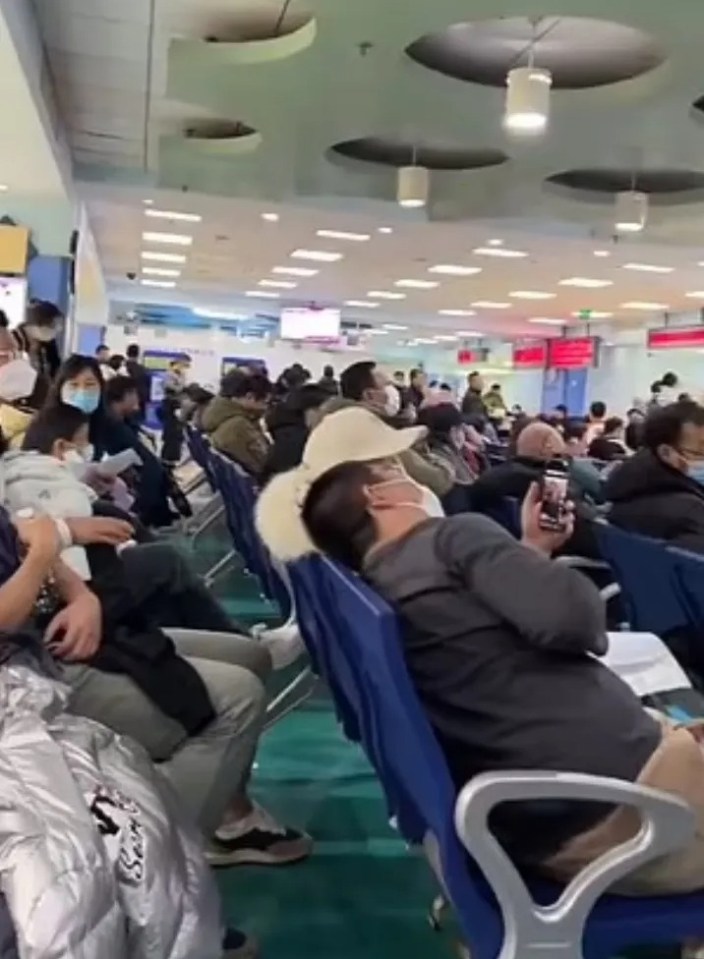 Crowded waiting area with many people wearing masks.