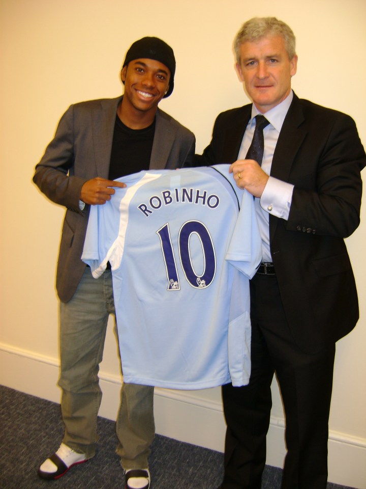 Robinho and Manchester City manager Mark Hughes holding up Robinho's new jersey.