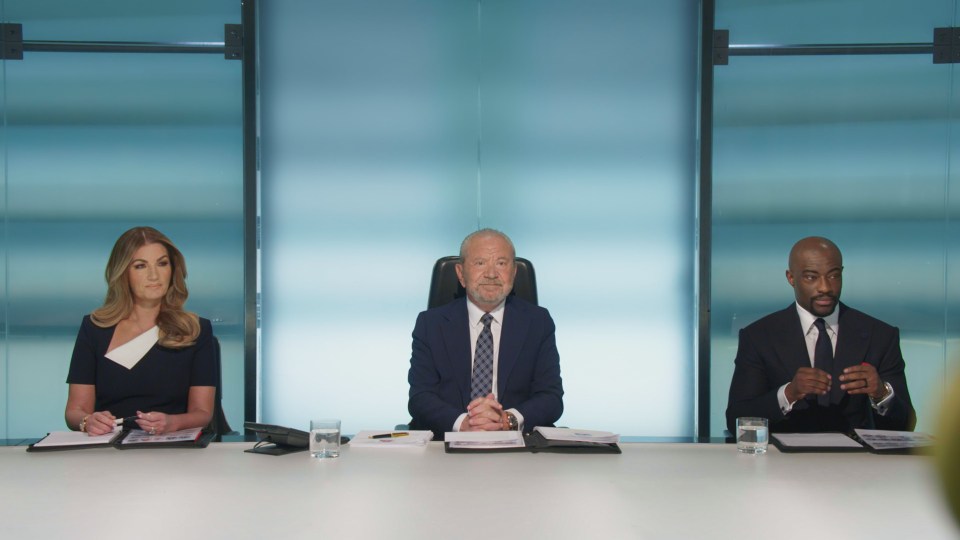 Lord Sugar and his aides in a boardroom.