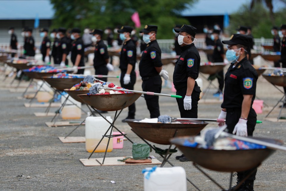 Police officers burning confiscated drugs at a ceremony.