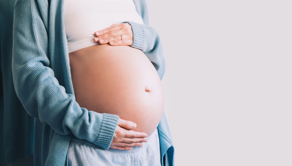 Pregnant woman holding her belly.