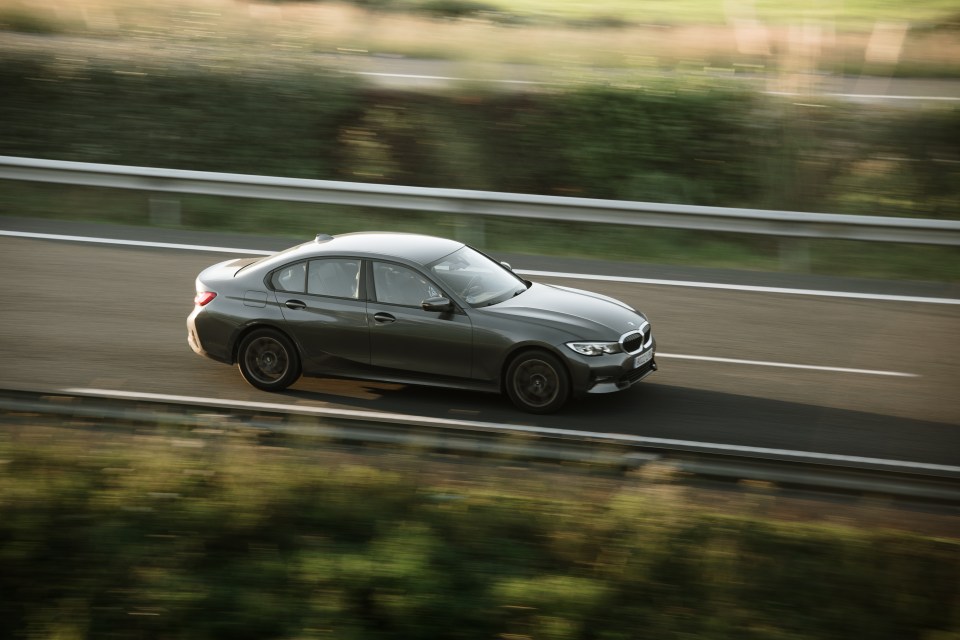 BMW 3 Series driving on a highway.