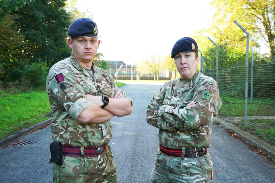 Two bomb squad members in uniform stand with arms crossed.