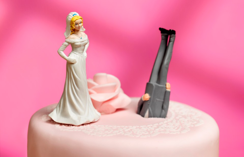 Illustration of a bride and groom figurine on a wedding cake; the groom is upside down.