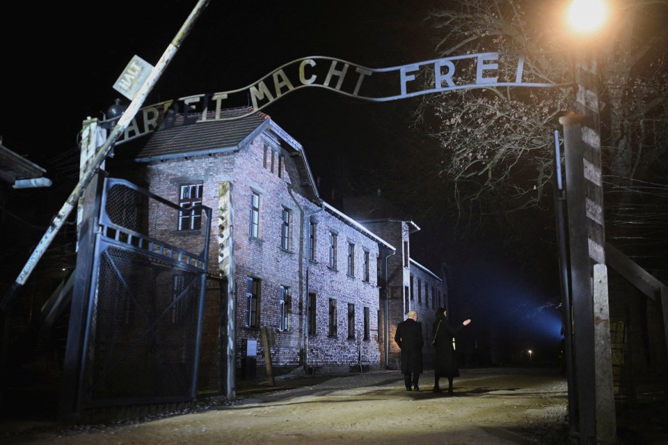 King Charles at Auschwitz-Birkenau's Arbeit Macht Frei gate.