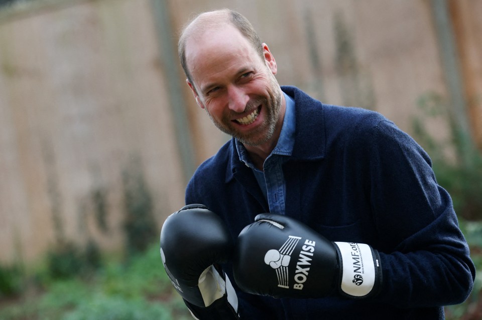 Prince William wearing boxing gloves at a charity event.