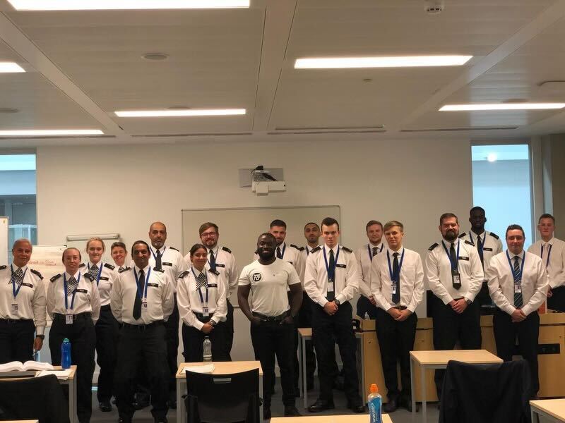 Group photo of police officers in a classroom.