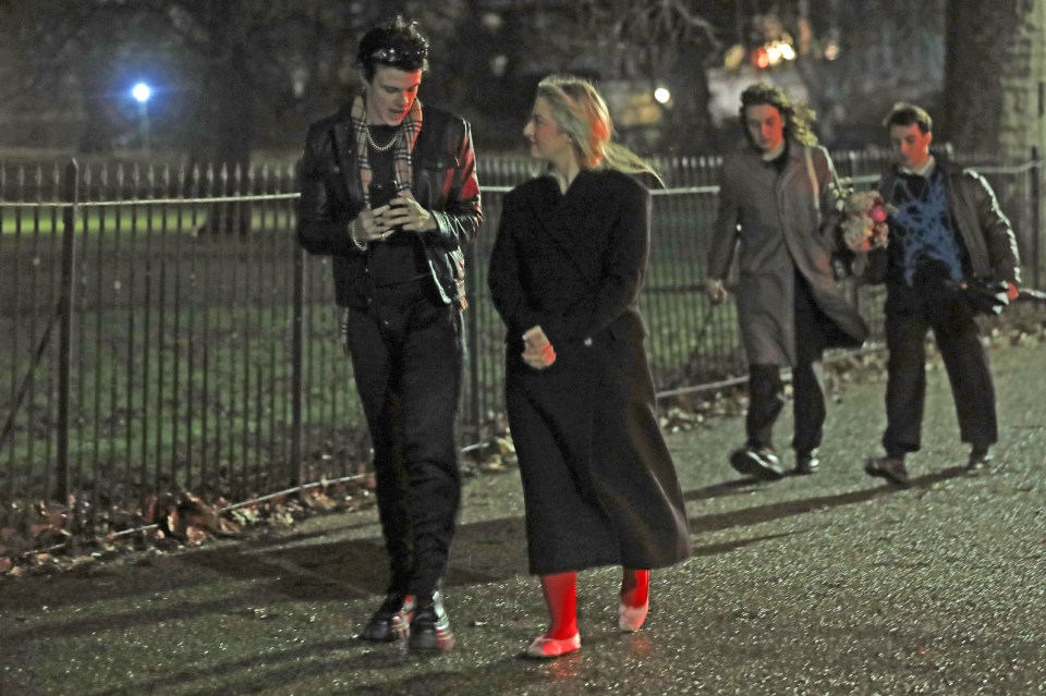 Yungblud and Anaïs Gallagher walking arm in arm at night.