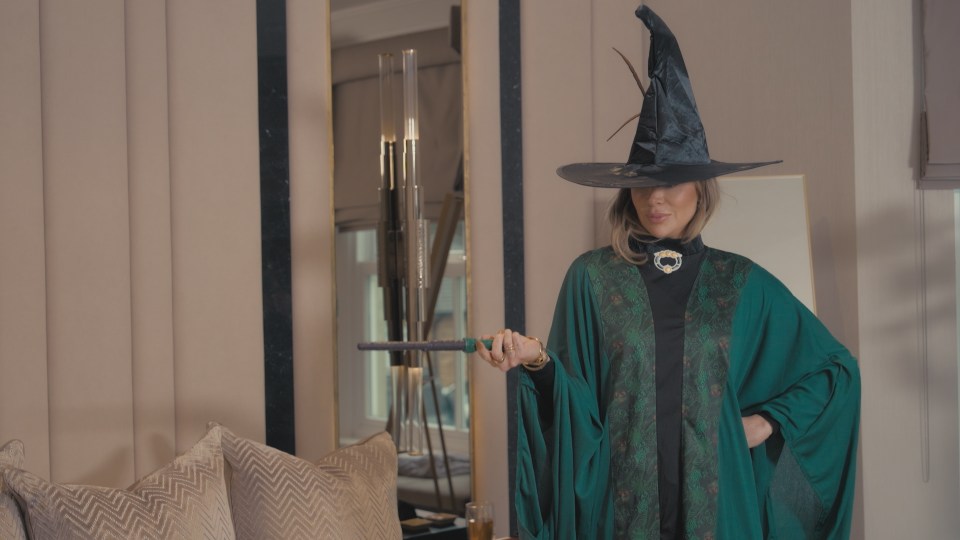 Woman in a witch costume holding a wand.