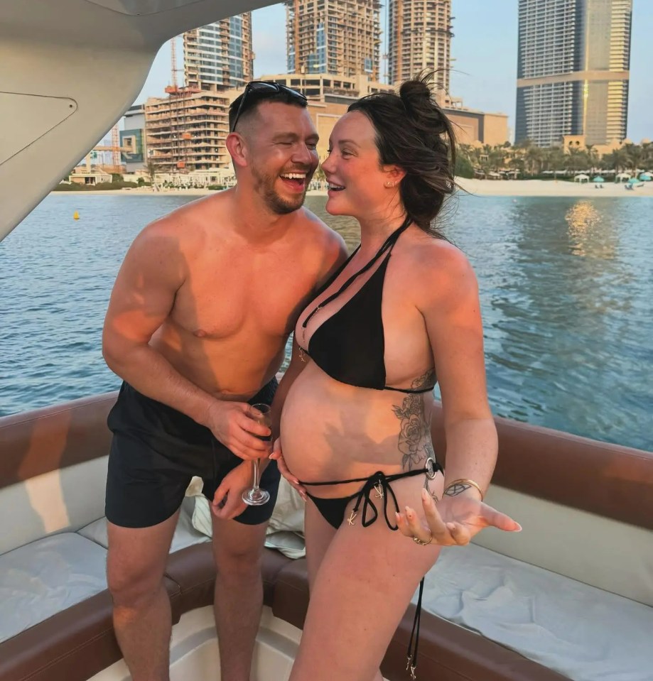 Pregnant woman and man laughing on a boat in Dubai.