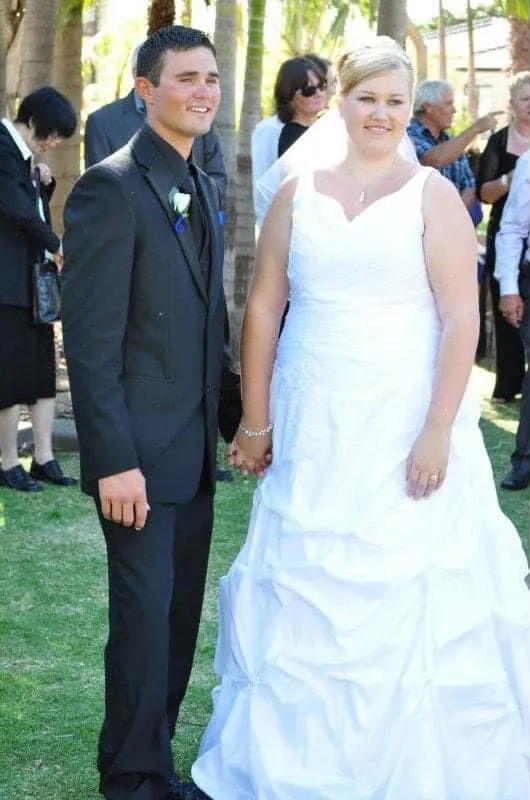 A bride and groom stand together on their wedding day.