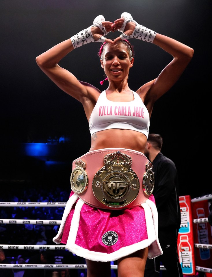 Carla Jade celebrates a boxing victory, making a heart shape with her hands.