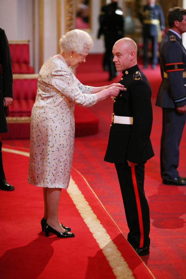 Queen Elizabeth II awarding a medal to Captain Benedict Stephens.