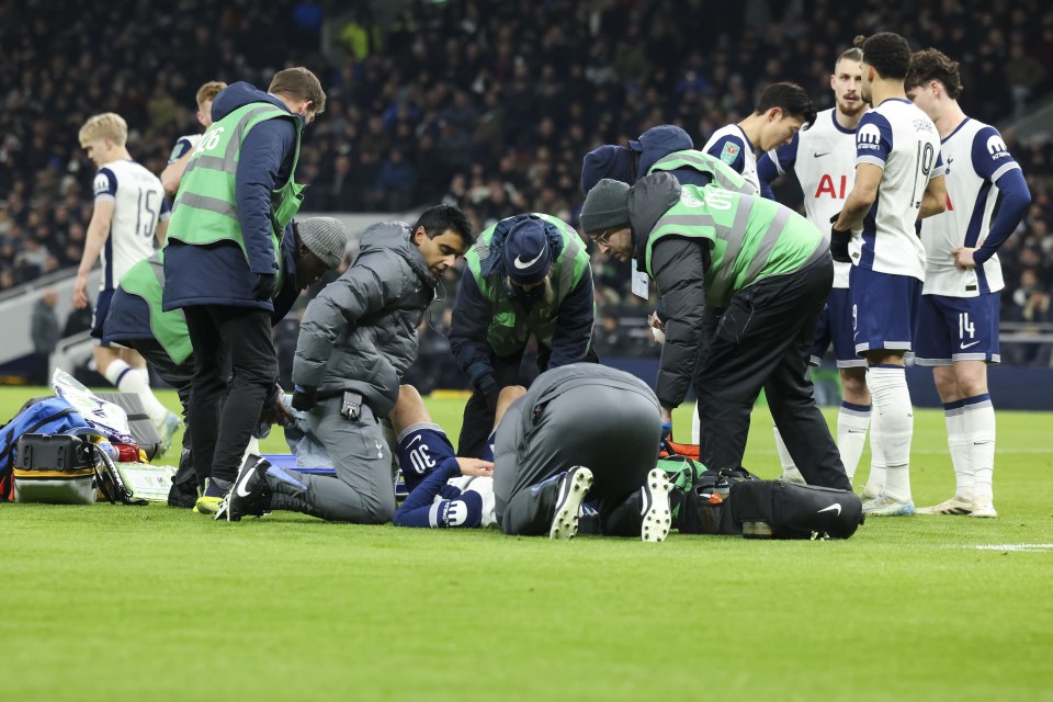 Injured Tottenham Hotspur player Rodrigo Bentancur receives medical attention on the field.