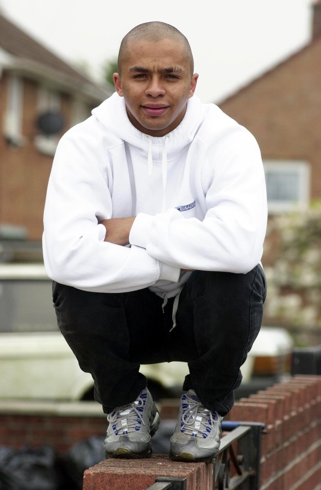 Huw Evans, Cardiff AFC player, crouching on a wall.