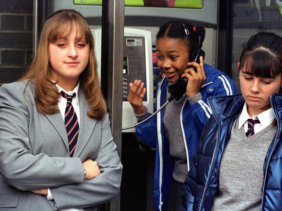 Three teenage girls react to news from a phone call.