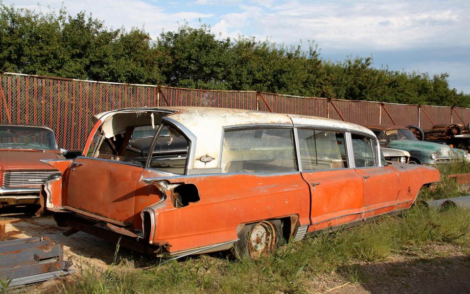 Rusty vintage cars in a junkyard.