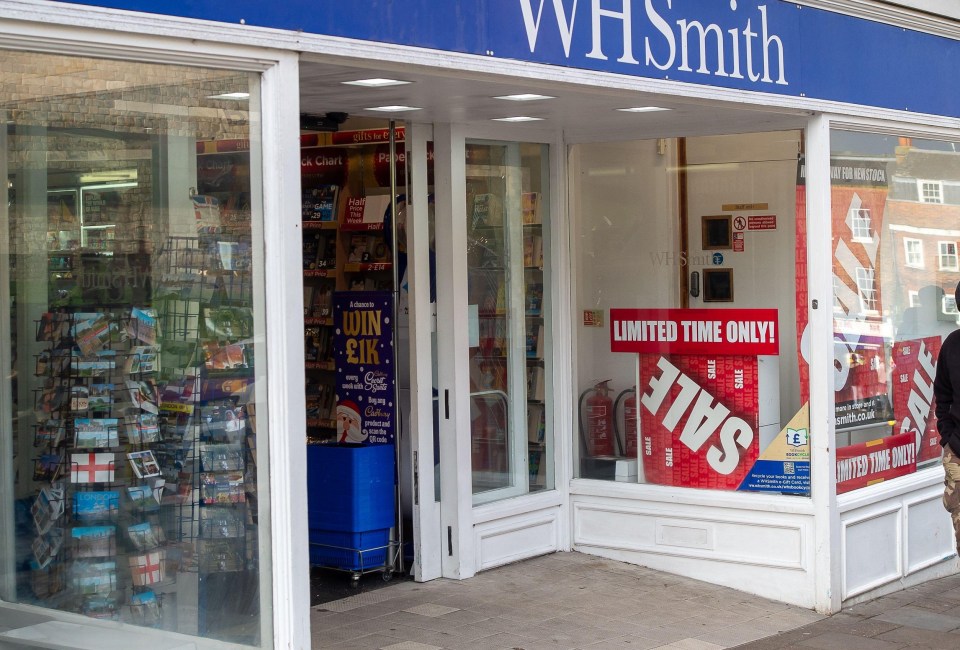 a man walks past a store called whsmith