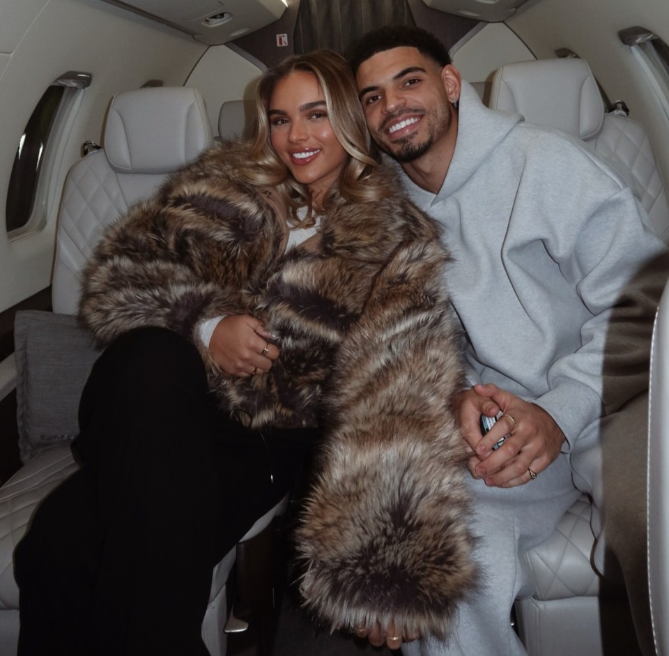 Couple holding hands on a private jet.