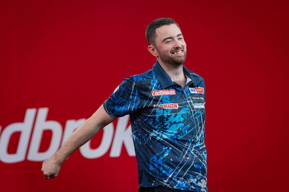 Luke Humphries celebrates winning a quarter-final darts match.