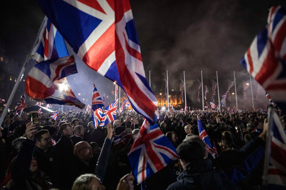 Pro-Brexit supporters celebrating in Parliament Square with Union Jack flags.