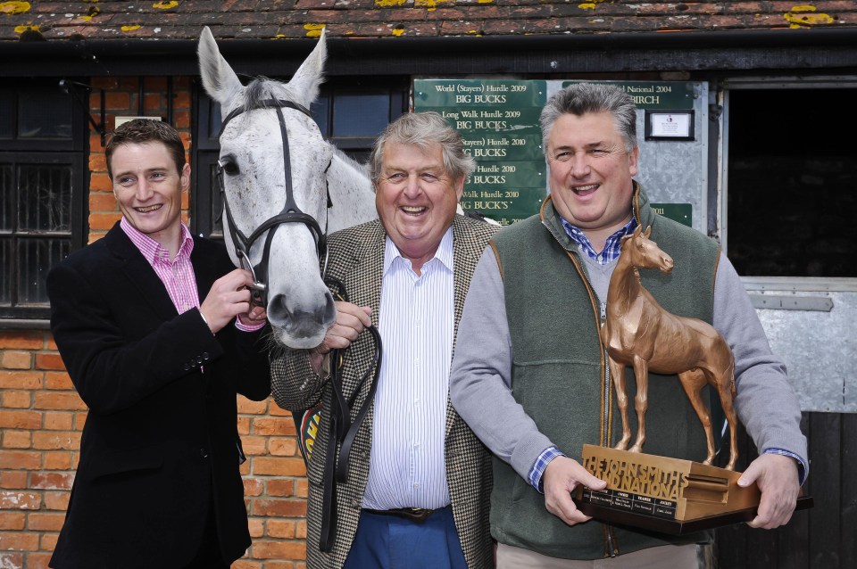 Grand National winner Neptune Collonges with jockey, owner, and trainer holding the winner's trophy.