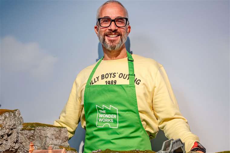 Olly Raeburn, CEO of Hornby Hobbies, wearing a green apron.