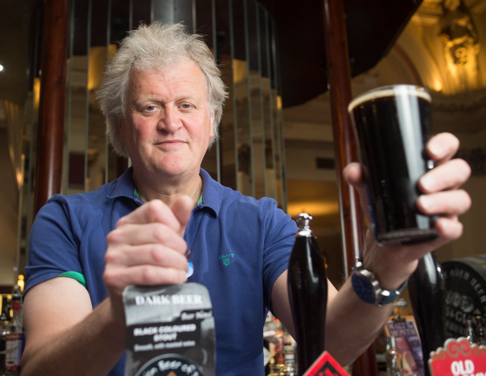 Tim Martin, chairman of Wetherspoons, holding a pint of dark beer.