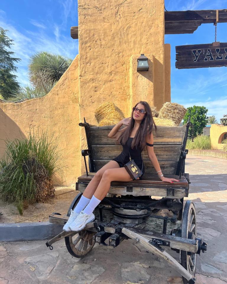 Woman sitting on a wooden wagon.