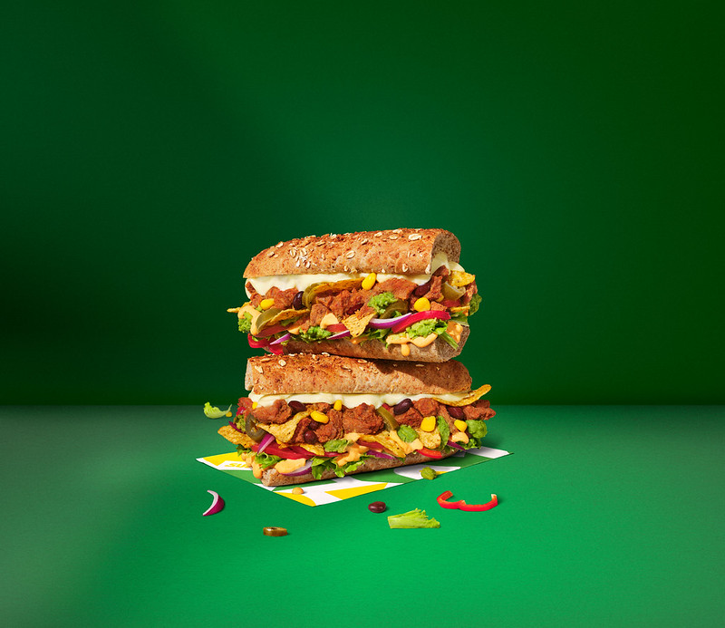 Two Subway Mexicana subs stacked on a green surface.