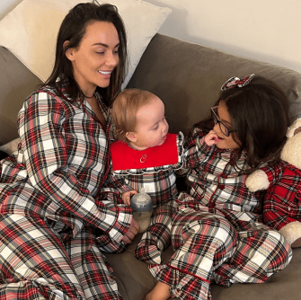 Mother and two children in matching plaid pajamas.