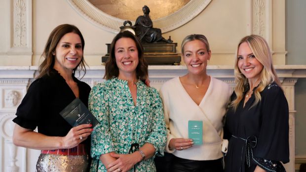 Four women holding wellness products.