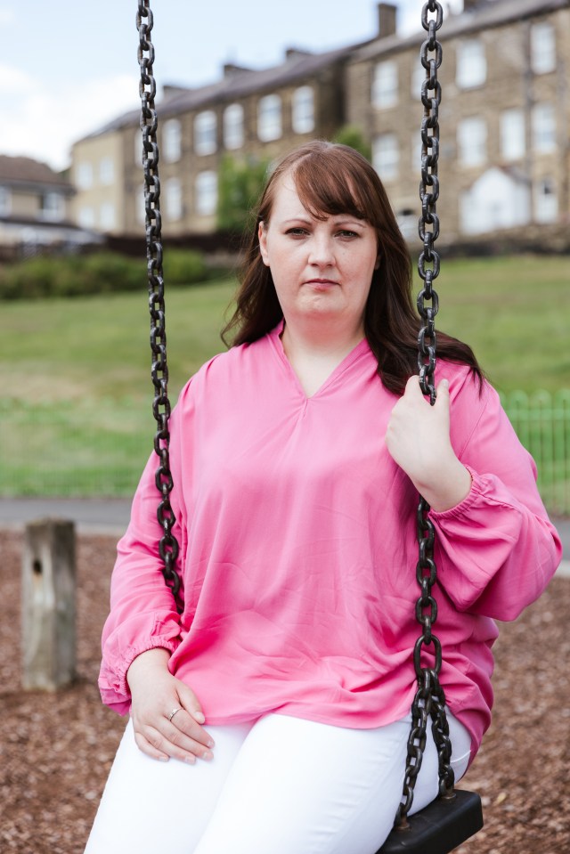 Woman sitting on a swing, looking at the camera.