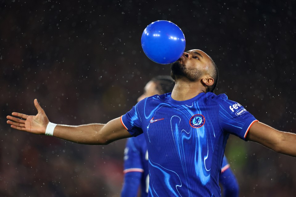 Christopher Nkunku of Chelsea inflates a blue balloon after scoring a goal.