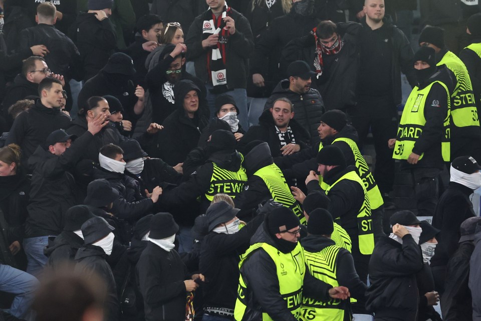 Stadium stewards intervening in a fight between soccer fans.