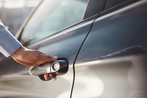 Close-up of a hand opening a car door.