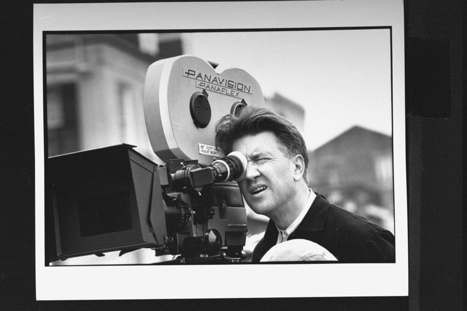 Black and white photo of David Lynch directing a film.