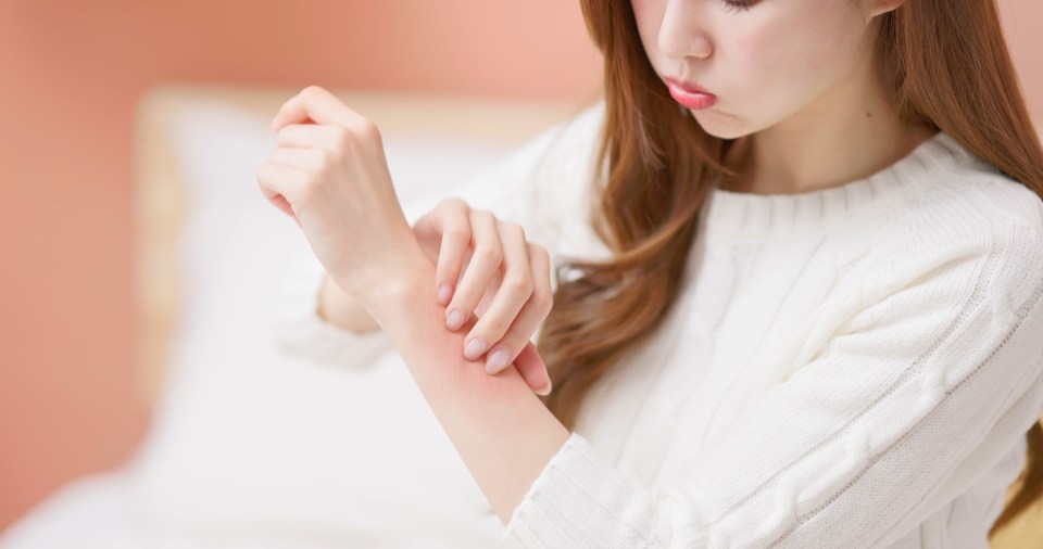 Woman scratching itchy arm.