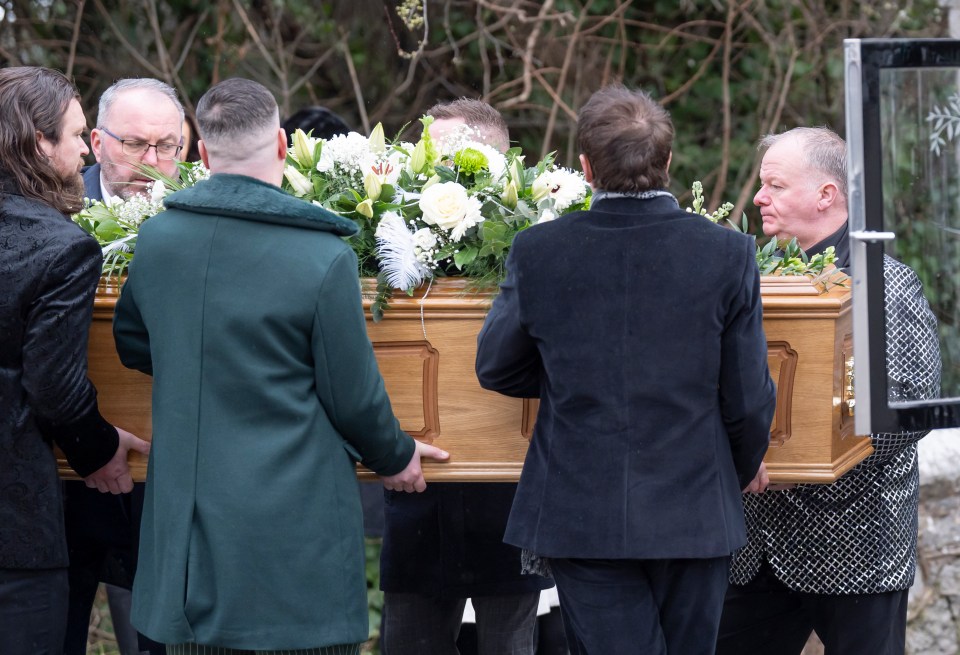 Pallbearers carrying The Vivienne's coffin at a funeral.