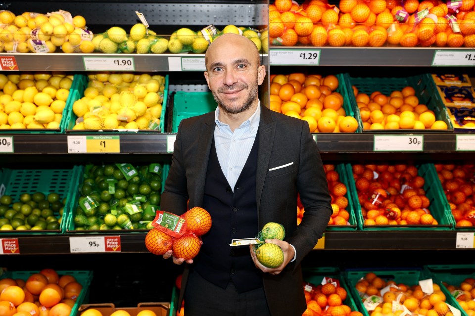 Morrisons CEO Rami Baitieh in a supermarket holding oranges and lemons.