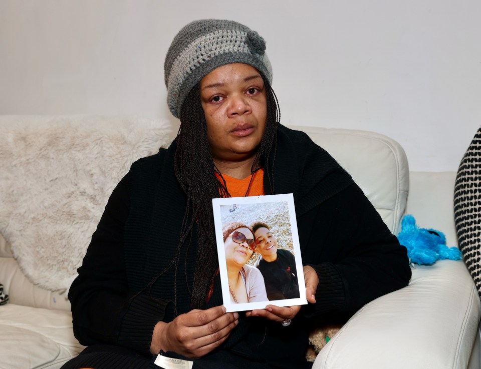 A grieving mother holds a photo of her deceased son.