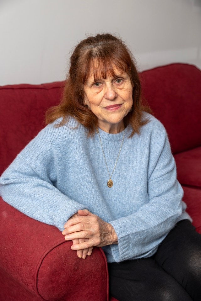 A woman sits on a red couch.