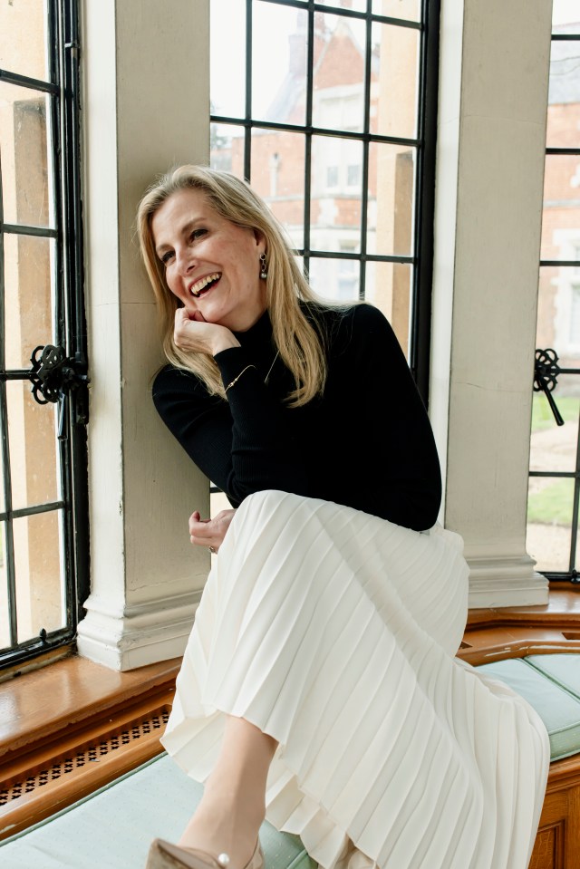 Portrait of the Duchess of Edinburgh, smiling and seated in a window seat.