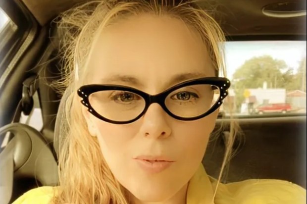 Aimee Betro, alleged hitwoman, in a yellow jacket and cat-eye glasses.