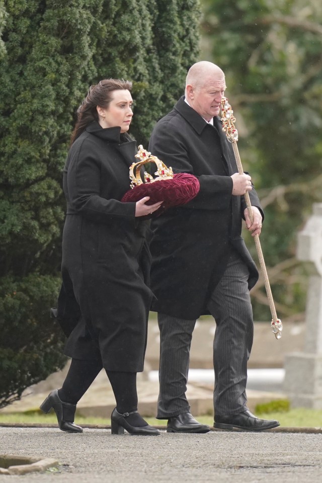 A crown and sceptre carried at a funeral.